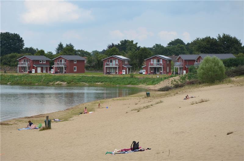 Blick auf die neuen Ferienhäuser im skandinavischen Stil und auf den neuen Badesee mit eigenem Strand.