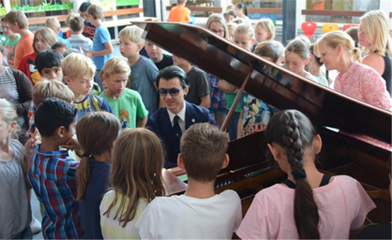 Das Buxtehuder Musikfestival macht Station in der Grunschule Altkloster: Umringt von seinen jungen Fans konzertiert Haiou Zhang in der Aula der Bildungsstätte.  Foto: Beneke
