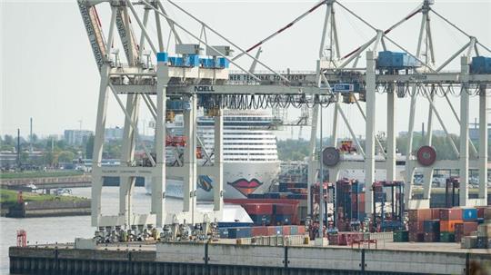 Das Kreuzfahrtschiff Aida Nova liegt im Hafen hinter Kränen eines Container-Terminals.
