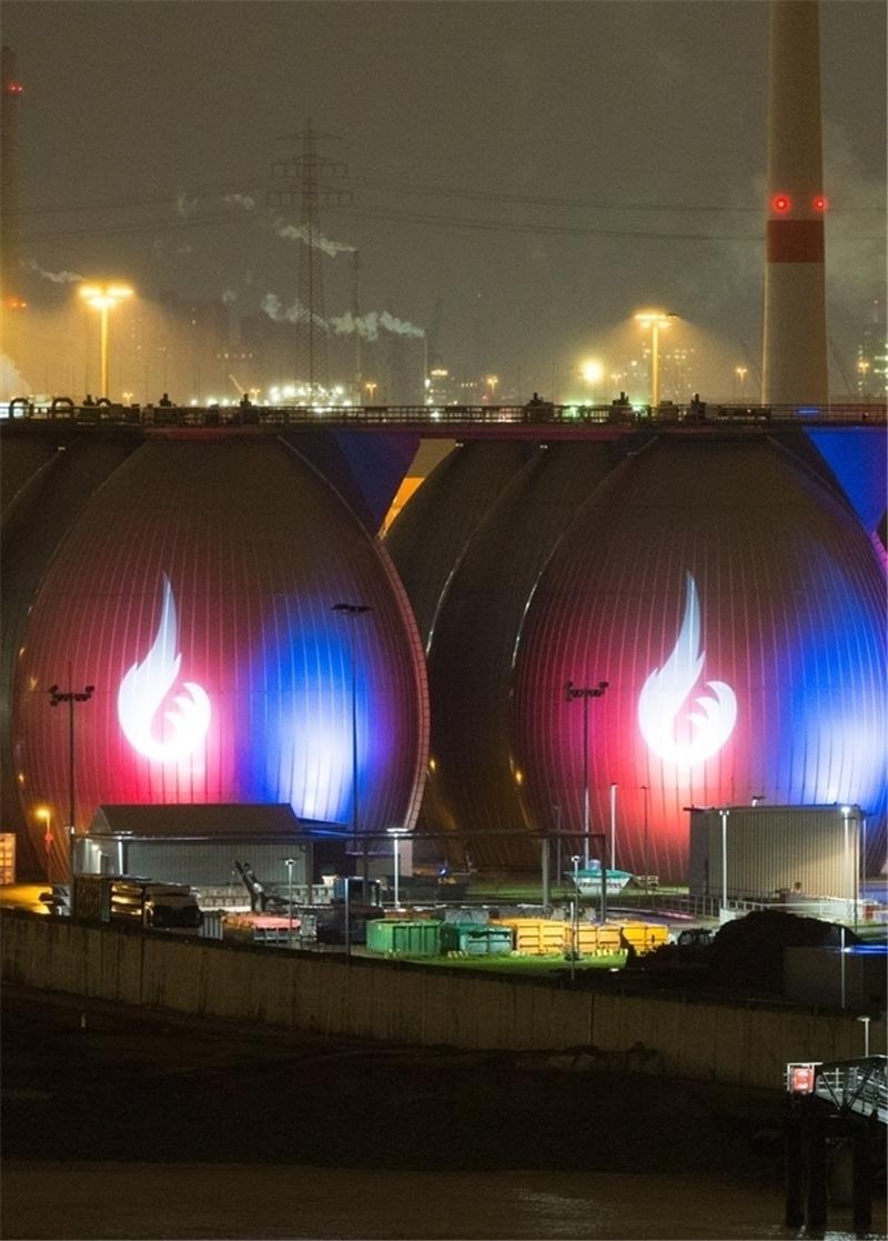 Das Logo der Olympia-Initiative „Feuer und Flamme für Hamburg“ ist als Illumination auf den Faultürmen des Klärwerks im Hafen in Hamburg zu sehen. Foto Charisius/dpa