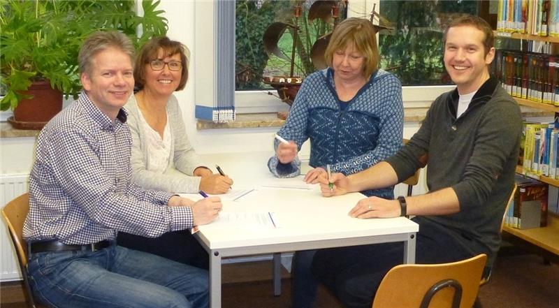 Der Kooperationsvertrag wird verlängert: Amtsleiter Tim Siol, Büchereileiterin Petra Abel, Schulleiterin Ursel Schirmer und Lehrer Matthias Mickeleit (von links) unterzeichnen den Vertrag in der Bücherei.