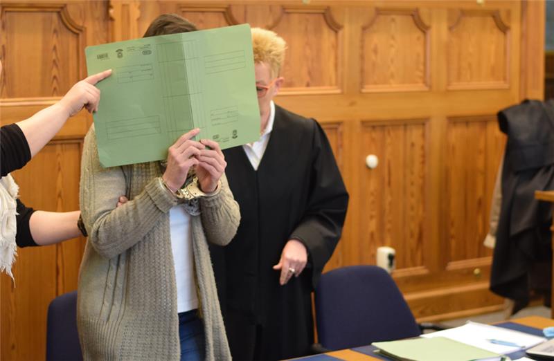 Die Beschuldigte versteckt am Tag des Prozessauftaktes ihr Gesicht hinter einem Papphefter. Archivfoto: von Borstel