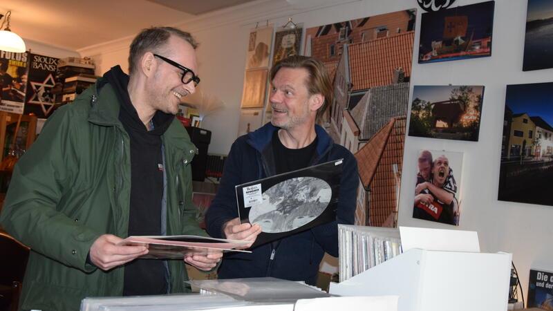 Zwei Männer im Gespräch im Schallplattenladen: Ihnen sieht man die Freude am Stöbern nach Schallplatten an.