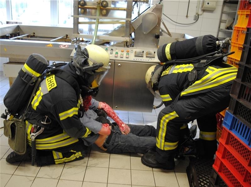 Diese Feuerwehrleute haben ein Brandopfer in der Bäckerei entdeckt und tragen es ins Freie. Fotos Vasel