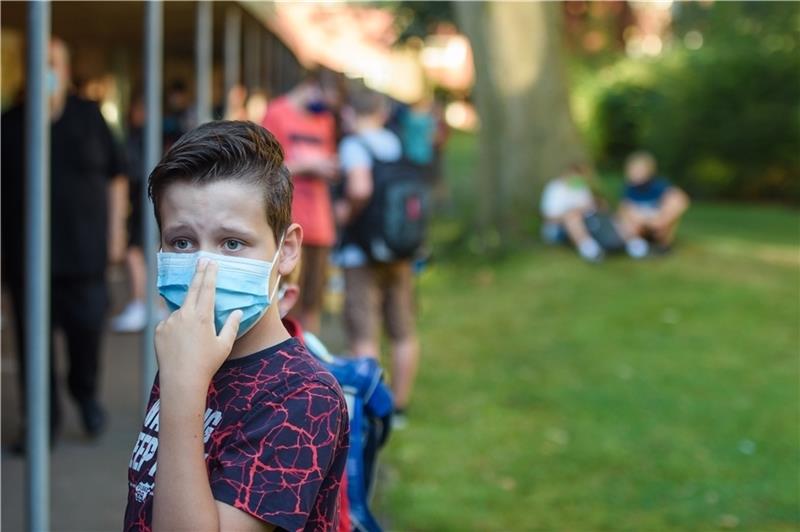 Ein Junge trägt eine Maske. Foto: Gregor Fischer/dpa