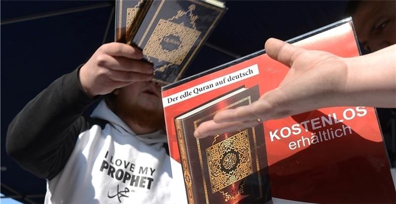 Ein Mann verteilt kostenlose Koran -Exemplare an Passanten. Foto Stratenschulte/dpa
