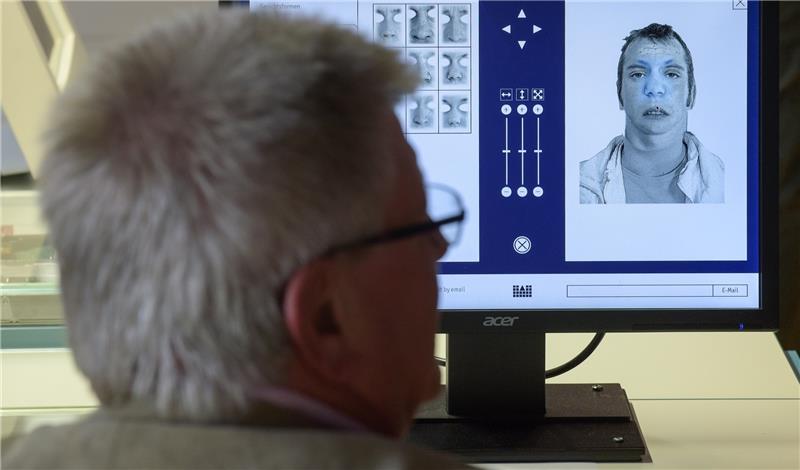 Ein Phantombildzeichner sitzt vor einem Bildschirm, an dem er Bilder von Tatverdächtigen herstellt. Foto Heimken/dpa