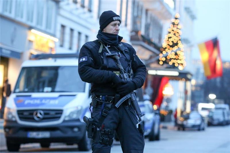Ein Polizist mit einer Maschinenpistole steht am 07. Dezember vor dem Hotel Vier Jahreszeiten in Hamburg, in dem während des OSZE-Treffens US-Außenminister Kerry untergebracht ist. Die Tagung des OSZE-Ministerrats am 8. und 9. Dezember beschert Hamburg einen riesigen Polizeieinsatz mit mehr als 13.000 Beamten. Foto: Bodo Marks/dpa