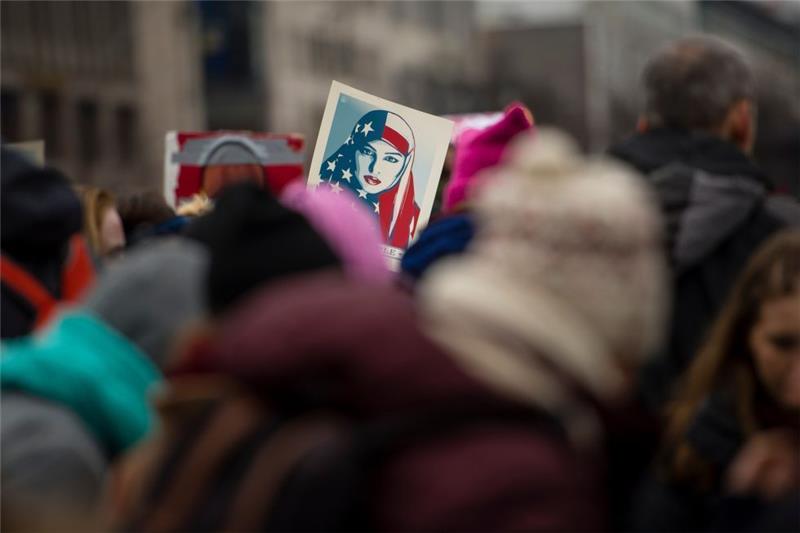 Ein Schild zeigt am 21. Januar auf einer Demonstration der "Democrats Abroad" gegen Donald Trump als Präsident der Vereinigten Staaten von Amerika in Berlin ein von Shepard Fairey entworfenes Motiv. Foto: Gregor Fischer/dpa