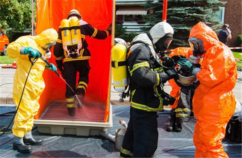 Feuerwehrleute werden in Hamburg nach ihrem Einsatz beim Brand des Hochbunkers dekontaminiert. Fotos dpa