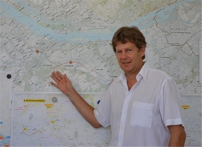 Hans-Jürgen Haase erläutert die Autobahn-Pläne an der Wand seines Stader Büros.