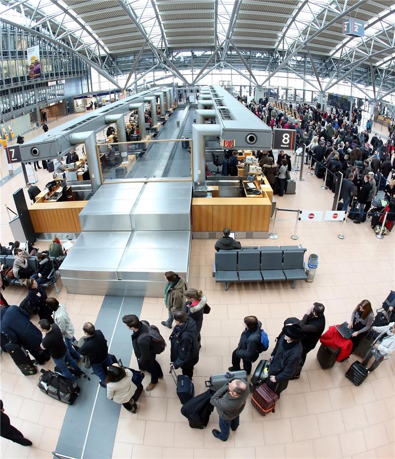 Hunderte Flugpassagiere warten auf die Abfertigung an den Check-In-Schaltern. Foto Marks/dpa