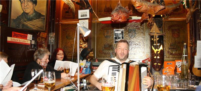 „La Poloma, ohe – einmal muss es vorbei sein...“ Ben O. Bömke ist Vorleser und Musikant in einem – und sorgt mit seinem Akkordeon für fröhliche Hafenkneipenstimmung in der Hamburger „Haifischbar“. Fotos Andrae