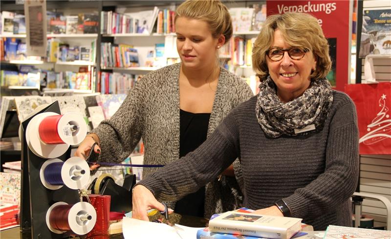Lena Neumann (links) und Hildegard Veichtlbaur verpacken in der Stackmann Buchhandlung die Weihnachtseinkäufe der Kunden. Foto Meybohm
