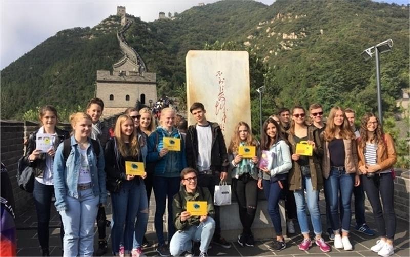 Mit den 23 Schülern des Gymnasiums Süd ist auch der Buxtehuder Bulle nach China gereist – hier lassen sie sich mit dem Bullen-Koffer auf der großen Mauer fotografieren. Außerdem übergab Reiseleiterin Dr. Jia Ma im Namen des Förderkreises de