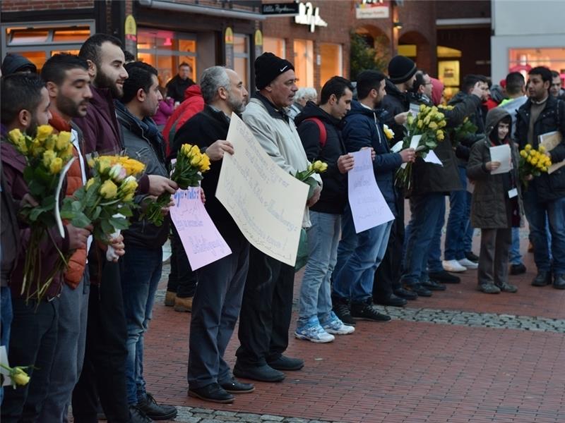 Mit gelben Rosen und Botschaften auf Deutsch und Arabisch bitten die Asylsuchenden um Entschuldigung.