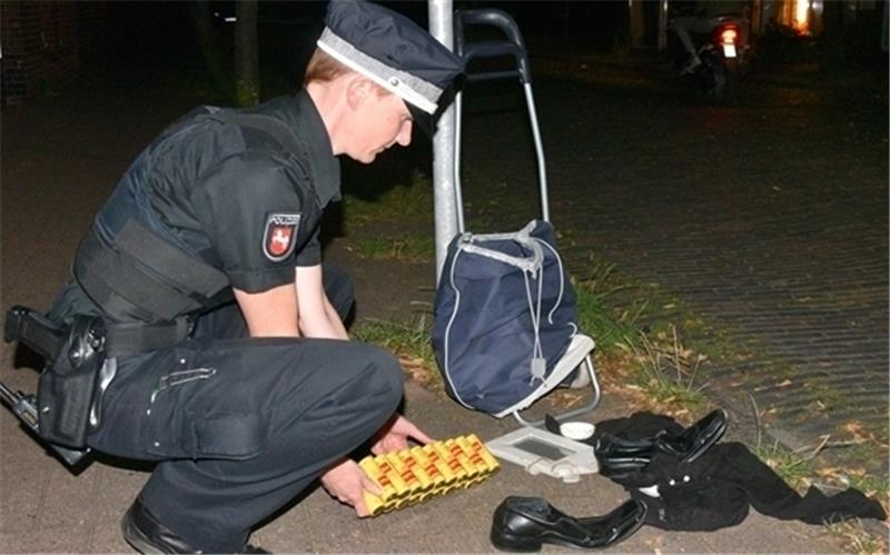 Polizeioberkommissarin Anne Zernikow zeigt den Inhalt des herrenlosen Trolleys: Kleidung, Batterien und ein Bilderrahmen. Foto Beneke