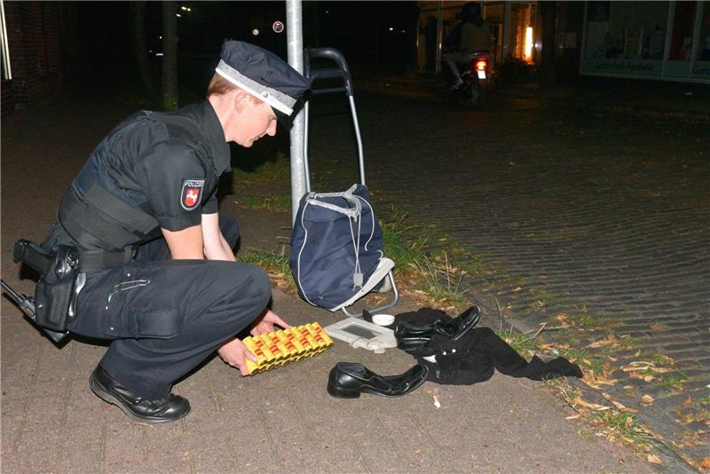 Polizistin Anne Zernikow zeigt den Inhalt des herrenlosen Trolleys: Kleidung, Batterien und ein Bilderrahmen. Fotos Beneke