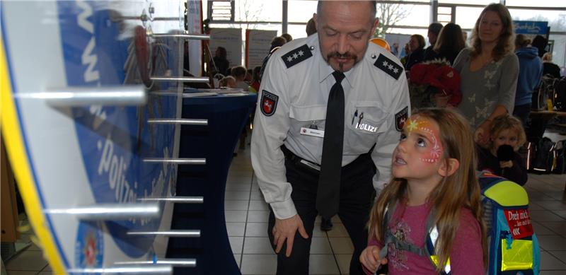 Theresa Karaxha (5) dreht mit Hilfe von Polizeihauptkommissar Thomas Mehnen das Glücksrad auf der Schulranzenmesse in Beckdorf. Fotos Felsch