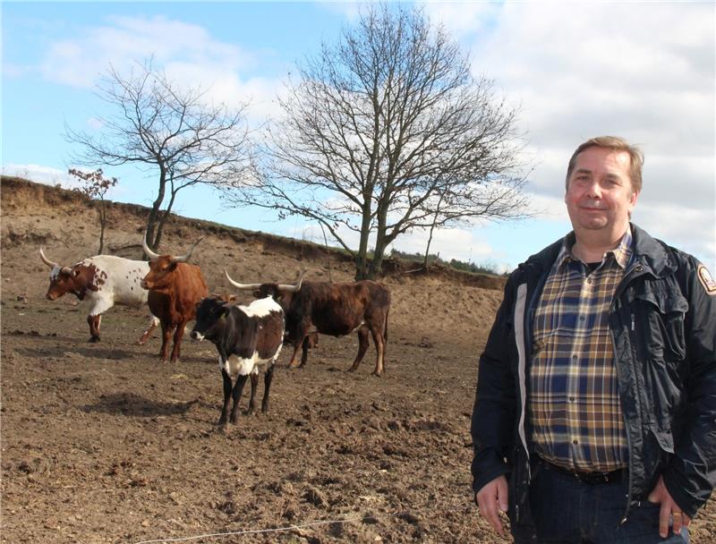 Thomas Hauschild bei seinen Texas Longhorns . Die Rinderrasse mit ihren langen Hörnern ist „auch was fürs Auge“, findet der 52-jährige Neu-Landwirt. Zaungäste können seine verschiedenen Tierrassen auf den Weiden am Moorweg beobachten. Fotos