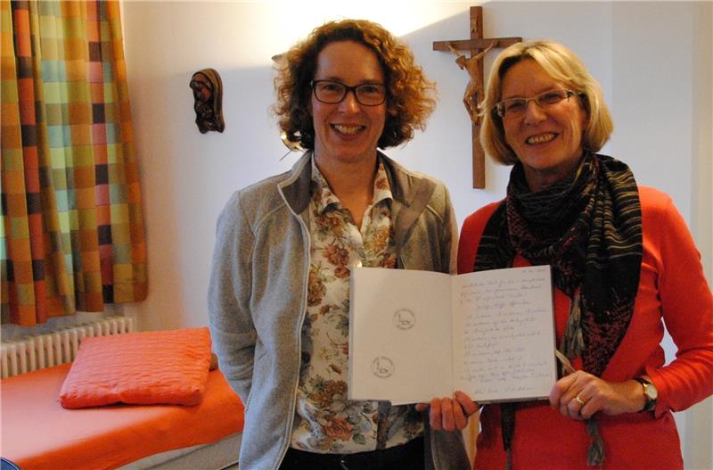 Zeigen das Pilgerbuch in der frisch renovierten Pilgerherberge : Birgit Domke und Maria Schimmöller (rechts). Oben der Stempel. Foto Stief