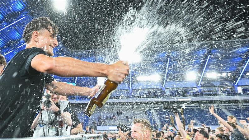  Arena. Spieler von SC Paderborn 07 spritzt mit einer Sektflasche im Stadion.