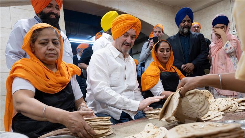  Bayerns Ministerpräsident Markus Söder besucht die Großküche des Sikh-Tempel „Gurudwara Bangla Sahib“ in Neu-Delhi und trägt dabei einen Turban auf dem Kopf.