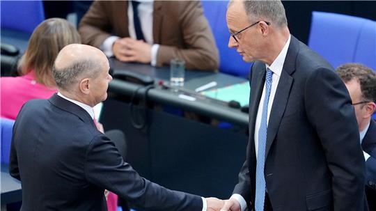  Der geschäftsführende Bundeskanzler Olaf Scholz (SPD, l) wünscht dem designierten Bundeskanzler Friedrich Merz (CDU) mit Bundestag beim zweiten Durchgang der Kanzlerwahl per Handschlag Glück. Nach dem Scheitern von CDU-Chef Merz im ersten Anlauf bei der Wahl zum Bundeskanzler soll es noch am Dienstag einen zweiten Wahlgang im Bundestag geben.