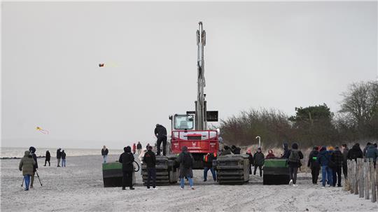  Ein Spezial-Schwimmbagger (M) steht zwischen Schwimmpontons am Strand bei Niendorf, wo ein Wal im flachen Wasser gestrandet ist. Für den Buckelwal, der an der Ostseeküste vor Niendorf gestrandet ist, ist eine weitere Rettungsaktion geplant. 