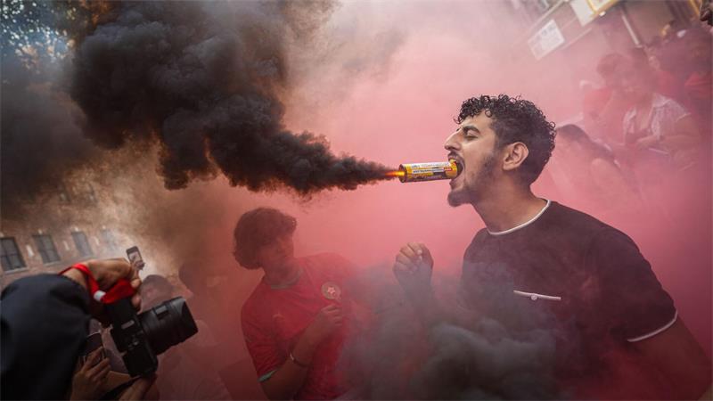  Ein marokkanischer Fan hält im New Yorker Stadtteil Queens eine Leuchtfackel mit dem Mund, nachdem die Mannschaft das Viertelfinalspiel der Fußball-Weltmeisterschaft gegen Frankreich verloren hat.