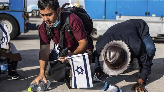  Indische Immigranten der «Bnei Menashe» halten israelische Flaggen und knien bei ihrer Ankunft am Flughafen Ben Gurion auf dem Boden.