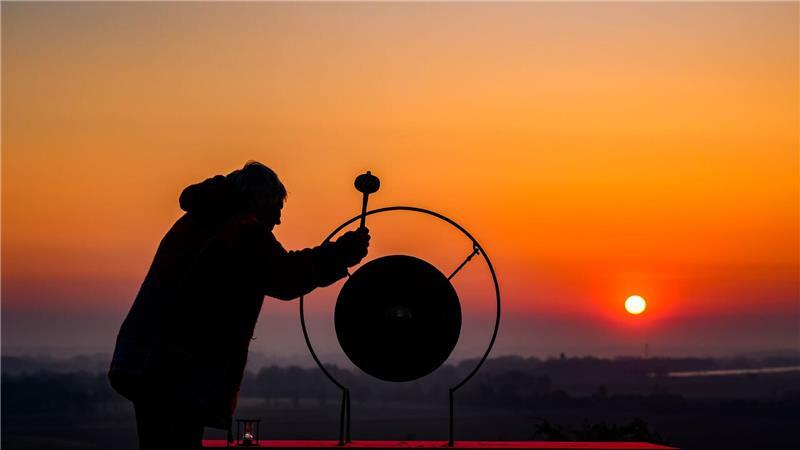  Künstlerin Heike Mildner schlägt zum Sonnenaufgang auf dem Krugberg in Seelow  einen Gong zum Gedenken an die Schlacht um die Seelower Höhen im April 1945. Vom 16. April um drei Uhr morgens bis zum Abend des 19. April wird dort ununterbrochen ein Gong angeschlagen - 87 Stunden lang, so lange wie die Schlacht um die Seelower Höhen idauerte. 