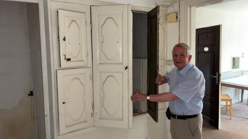 Ortskurator Dr. Reinhold Kolck öffnet einen alten Wandschrank.
