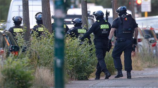  Polizisten sind in der Nähe von einem Supermarkt im Einsatz.