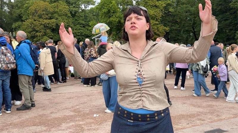 Gesichter der Trauer: So erinnern sich Norweger an Harald Sonya Lii Nome Barlow singt auf dem Schlossplatz ein Lied zu Ehren von Harald V.
