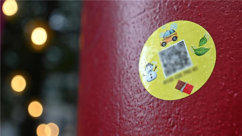  Sticker mit einem QR-Code zur Bestellung von Drogen klebt an einer Säule.
