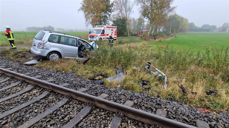  Trümmerteile des Zugs und Autos liegen neben den Gleisen.