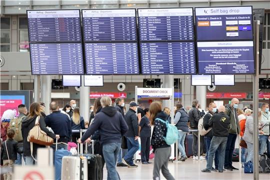 01.10.2021, Hamburg: Reisende sind am Flughafen Hamburg unterwegs und gehen an einer Anzeigetafel entlang. Zahlreiche Urlauber starten heute in die Herbstferien. Foto: Bodo Marks/dpa +++ dpa-Bildfunk +++