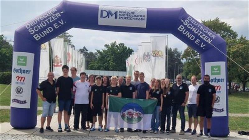 Auf dem Bild ist eine junge Mannschaft, bestehend aus 13 Schützen und ihren Betreuern zu sehen. Die meisten tragen schwarze Shirts mit dem Vereinslogo auf der Brust und dunklen Jeans. Die  Jugendlichen in der Mitte halten das Wappen von Altkloster in der Hand: Quergestreift ist die untere Hälfte weiß, die obere hat ein gedecktes Dunkelgrün. darauf ist ein Oval zu erkennen, auf welchem ein kleines Dorf zu sehen ist. Die Mannschaft des Altklsoter SV steht unter eine, aufblasbarem Tor.