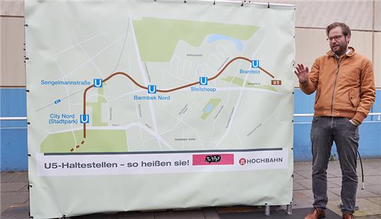 17.12.2021, Hamburg: Anjes Tjarks (Bündnis 90/Die Grünen), Verkehrssenator, steht während einer Pressekonferenz zur neuen U-Bahnlinie U5 in der Gründgensstraße in Steilshoop neben einem Banner mit den zukünftigen Namen der U-Bahnstationen City Nord (Stadtpark), Sengelmannstraße, Barmbek Nord, Steilshoop und Bramfeld. Foto: Georg Wendt/dpa