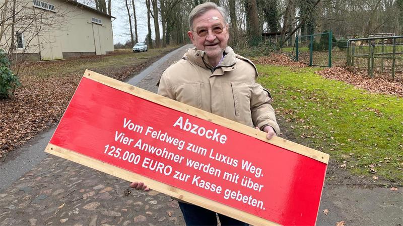 2022 hält Paul Müller ein Protestschild in der Hand.