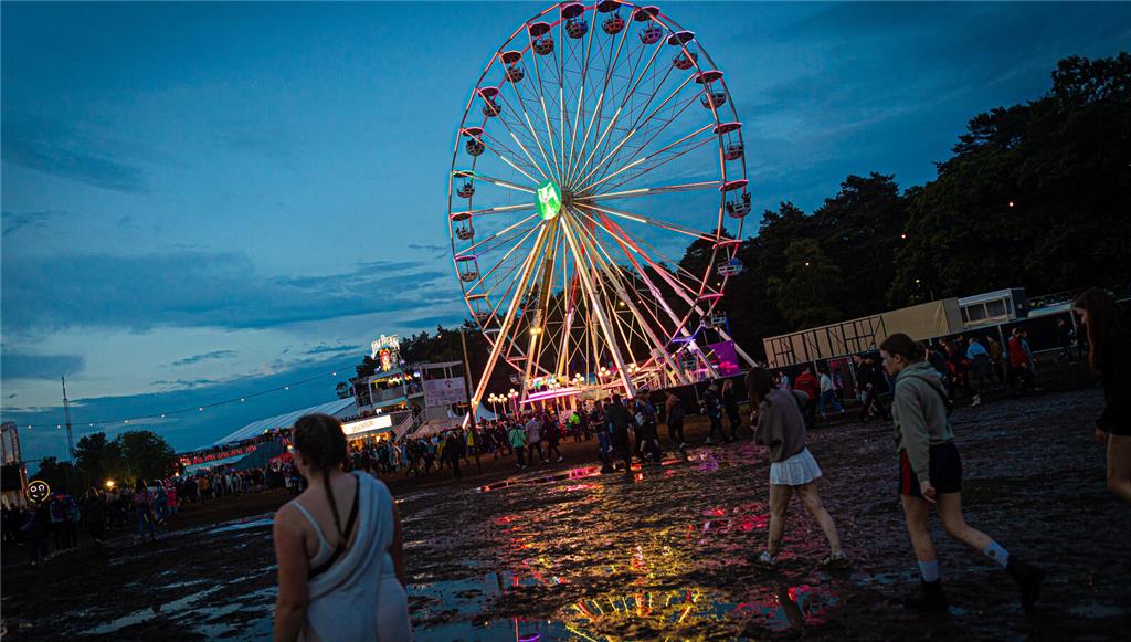 21.06.2024, Niedersachsen, Scheeßel: Ein Riesenrad dreht sich am Abend auf dem G...