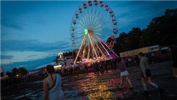21.06.2024, Niedersachsen, Scheeßel: Ein Riesenrad dreht sich am Abend auf dem Gelände des Hurricane Festivals und spiegelt sich in Pfützen. Das Open-Air-Festival findet vom 21. bis zum 23.06. statt. Foto: Moritz Frankenberg/dpa +++ dpa-Bildfunk +++