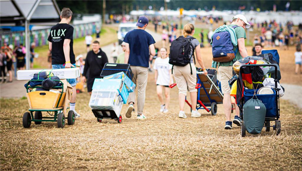 21.06.2024, Niedersachsen, Scheeßel: Festivalbesucher kommen mit ihrem Gepäck am...