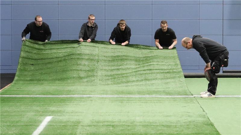 22 Meter lang und 4 Meter breit sind die Kunstrasenstücke, die die Firma Scholz im Sportcampus verlegt.