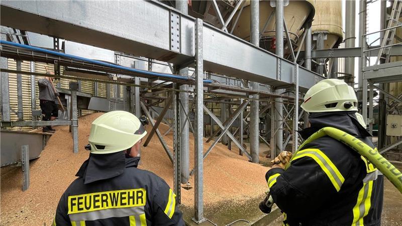 40 Tonnen Getreide müssen Mitarbeiter der Raisa aus dem Turm holen, Feuerwehrleute stehen bereit, um zu löschen.