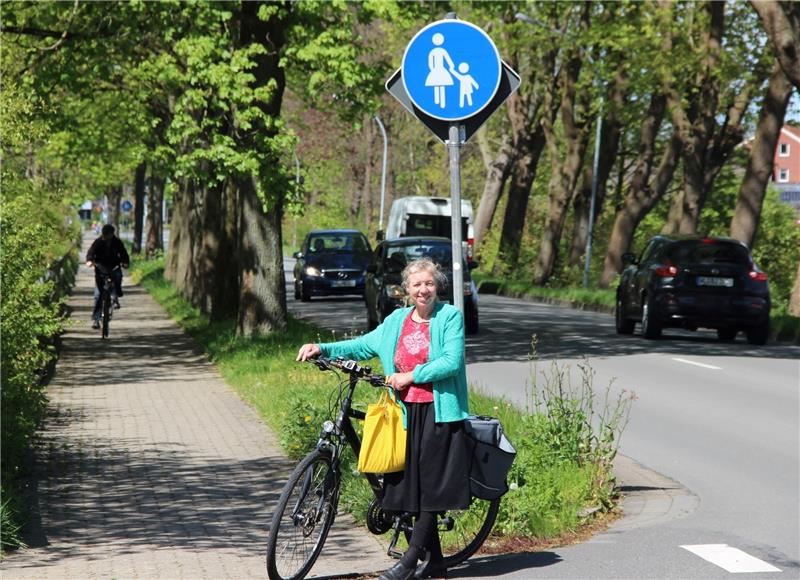 ADFC-Sprecherin Elisabeth Steinfeld macht auf die neue Lage an der Wulmstorfer Straße aufmerksam. Der Radfahrer im Hintergrund darf dort eigentlich nicht mehr fahren. Der Seitenweg ist jetzt ein reiner Fußgängerweg. Foto Michaelis
