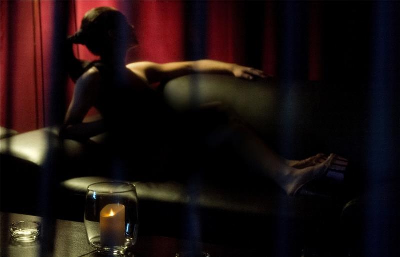 ARCHIV - Eine Prostituierte sitzt am 21.10.2013 in Böblingen (Baden-Württemberg) im Rahmen eines Fototermins auf dem Sofa eines FKK-Clubs. Foto: Marijan Murat/dpa (zu dpa-Berichterstattung über die Eröffnung einer Beratungsstelle für Prosti
