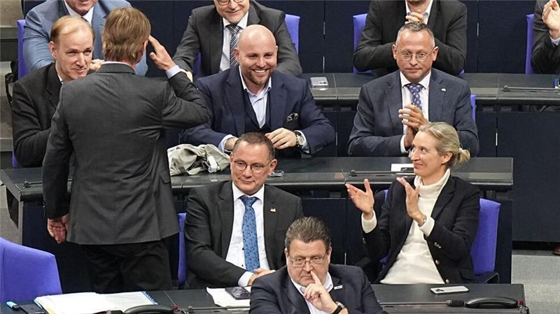 Abgeordnete der AfD-Bundestagsfraktion, unter ihnen die Fraktionsvorsitzenden Tino Chrupalla und Alice Weidel, freuen sich nach der Bekanntgabe des Ergebnisses der namentlichen Abstimmung über einen Antrag der Unionsfraktion zur Verschärfung der Migrationspolitik.