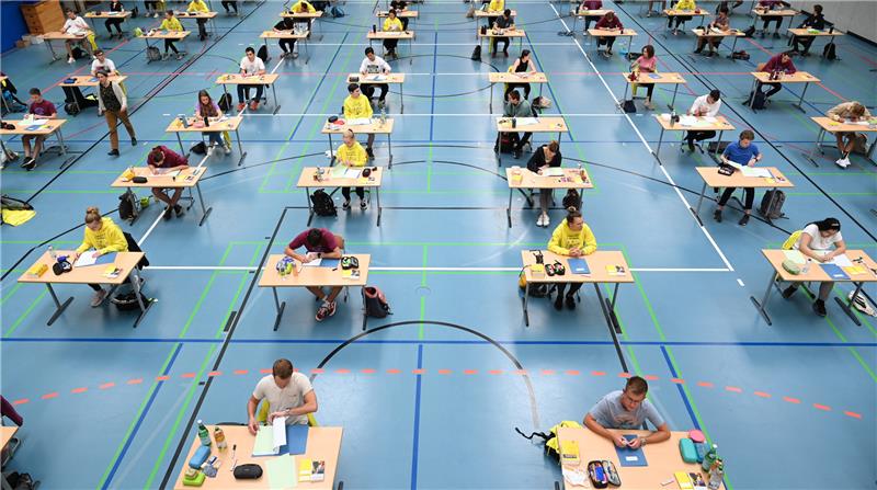 Abi-Prüfungen beginnen in Hamburg - ein letztes Mal mit Corona-Erleichterungen Abitur-Klausuren sind für die Beteiligten zwar ein Riesenstress. Doch die Anordnung der Prüflinge in einer bläulichen Turnhalle kanneinen ästhetischen Reiz haben. Foto: Felix Kästle/dpa